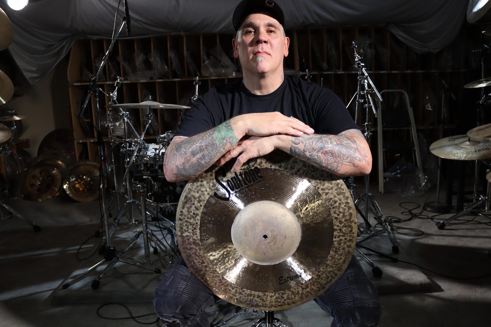 Chris Kontos resting his arms on a Soultone china cymbal in the studio